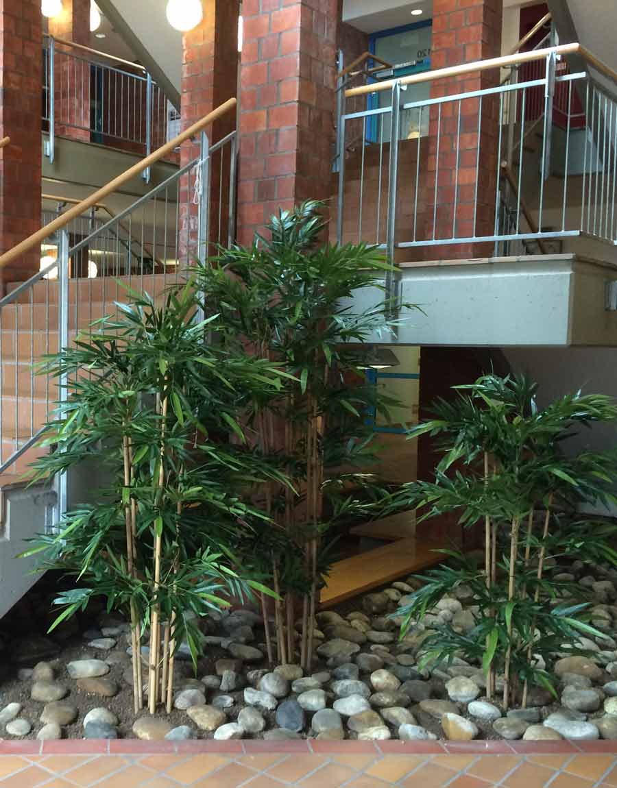 Künstlicher Bambus als langfristige Bepflanzung von einem Beet im Treppenhaus